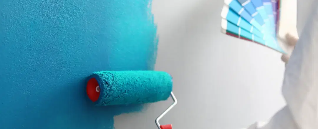 A painter rolling fresh paint onto an interior wall
